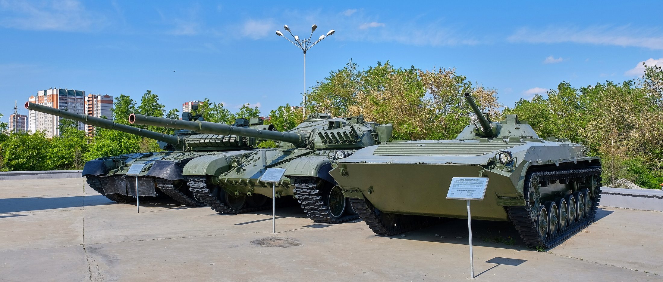 Площадка техники сейчас: Т-80, Т-72 и БМП-1 на бетонной площадке, таблички на штырях